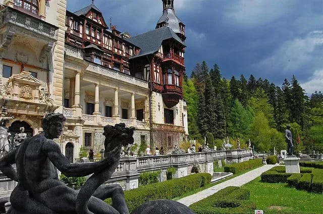 Пелеш Палац, старовинний королівський палац, на першому плані статуя чоловіка зі змією